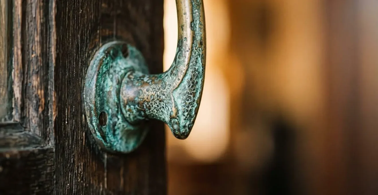 Close-up of worn brass door handle on weathered timber door in Melbourne laneway