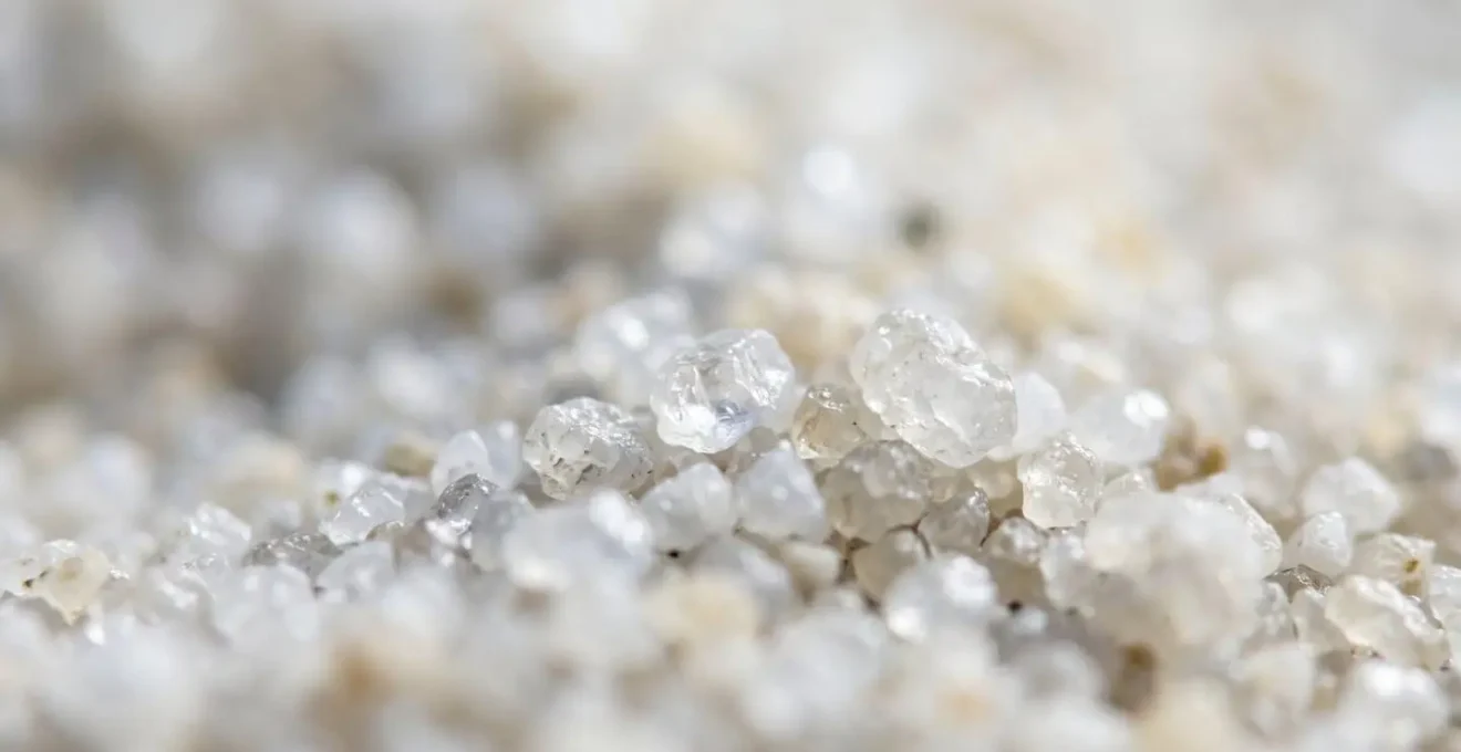Extreme macro closeup of pristine white silica sand grains showing crystalline structure and fine texture